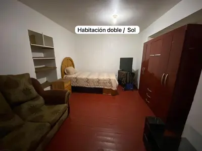 a living room with a bed and a couch at Casa Katya Cusco in Cusco