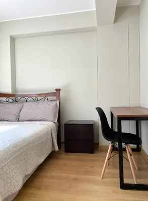 a bedroom with a bed and a desk with a chair at Departamento 17 personas San Isidro in Lima