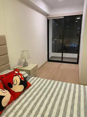 a bedroom with a bed with a large window at Apartamento en Barranco in Lima