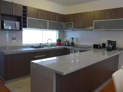 a kitchen with a counter with wine glasses on it at Spacious Apartment in Miraflores in Lima