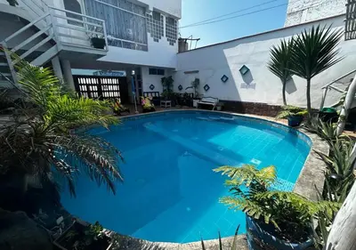 a large blue swimming pool in front of a building at Apartamento Playa Arica in Lurín