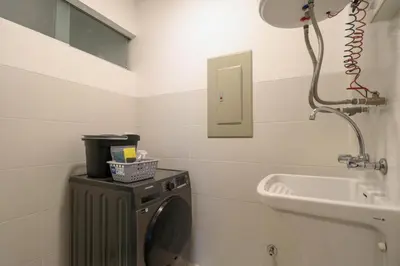 a bathroom with a washing machine and a sink at Narciso 350 by Wynwood House in Lima