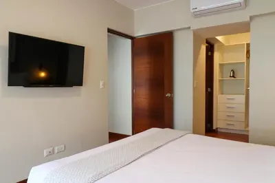 a bedroom with a bed with a flat screen tv on the wall at Narciso 350 by Wynwood House in Lima