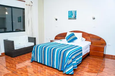 a bedroom with a bed and a chair at Casablanca Hotel in San Ramón