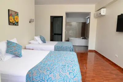 a hotel room with two beds and a bathroom at Casablanca Hotel in San Ramón