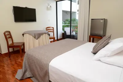 a bedroom with a bed and a flat screen tv at Casablanca Hotel in San Ramón