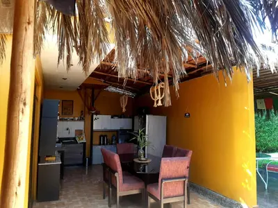 a dining room with a table and chairs and a kitchen at Casa - Hospedaje Munay Ki - Yoga - in Pisco
