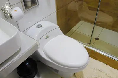 a bathroom with a white toilet and a shower at Terra Premium Hotel in Huánuco