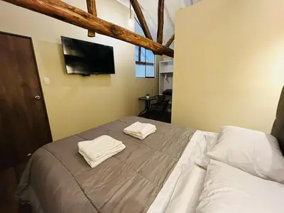 a bedroom with a bed with two towels on it at Casa Virgen del Carmen in Cusco