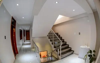 a spiral staircase in a home with white walls at Hotel Melthon Urbans in Ayacucho