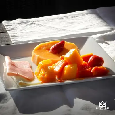 a plate of food with fruit on a table at Hotel Melthon Urbans in Ayacucho