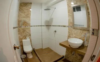 a bathroom with a toilet and a sink and a mirror at Hotel Melthon Urbans in Ayacucho