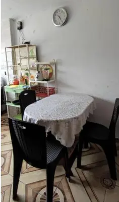 a dining room table with two chairs and a clock on the wall at LA POSADA CHASQUI Perú in Lima