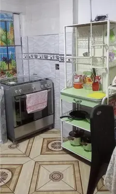 a kitchen with a stove and a microwave at LA POSADA CHASQUI INN en LIMA in Lima