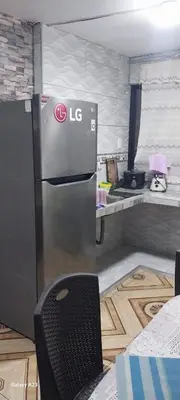 a kitchen with a refrigerator and a chair in it at LA POSADA CHASQUI INN en LIMA in Lima