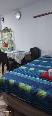 a bedroom with a bed with a blue and green blanket at LA POSADA CHASQUI INN en LIMA in Lima