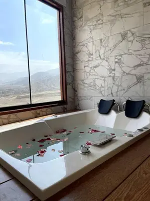 a bath tub with two chairs in a room with a window at Casa Dama in Cieneguilla