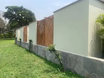 a retaining wall next to a house and a fence at FUNDO VIERA: Amplio y acogedor in Lima
