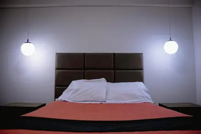 a bedroom with a bed with two lights above it at PRANA in Huancayo