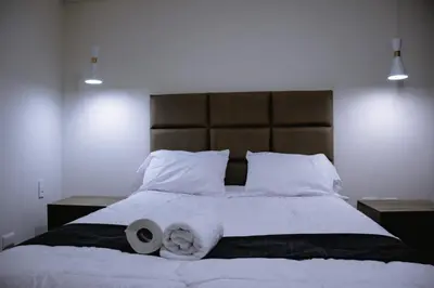 a bedroom with a large bed with two rolls of towels at PRANA in Huancayo