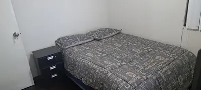 a bed with a comforter and a dresser in a bedroom at Acogedora Habitacion Independiente in Lima