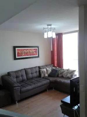 a living room with a couch and a window at Tait's House - Cómodo departamento Dúplex - Ate in Lima