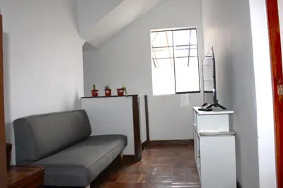 a living room with a couch and a window at Inti Wasi in Cusco
