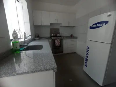a kitchen with a white refrigerator and a sink at Inti Wasi in Cusco