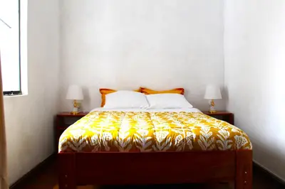 a bedroom with a bed with a yellow and white bedspread at Inti Wasi in Cusco