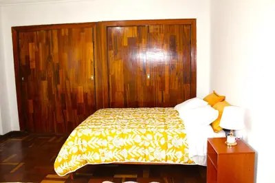 a bedroom with a bed with a wooden head board at Inti Wasi II in Cusco