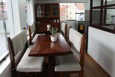 a wooden table with white chairs and a plant on it at Inti Wasi II in Cusco