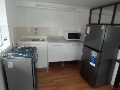 a small kitchen with a stove and a refrigerator at Inti Wasi II in Cusco