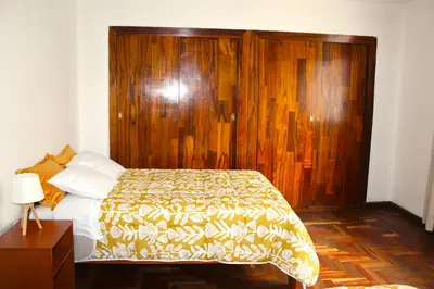 a bedroom with a bed with a wooden head board at Inti Wasi II in Cusco
