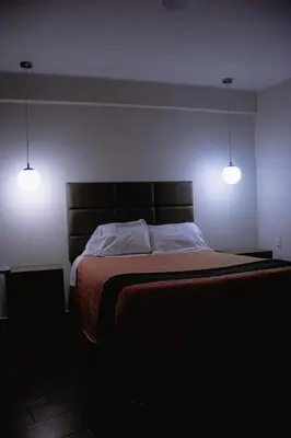 a bedroom with a bed with two lights on it at PRANA in Huancayo