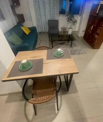 a wooden table with two cups on top of it in a living room at Huancayo Suite 4-Cómodo MiniDpto 2 camas in Huancayo
