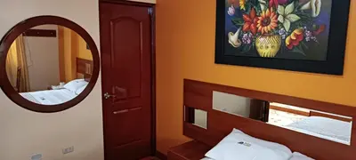 a bedroom with a mirror and a bed and a bed sidx sidx sidx at Hotel Allison in Huacho