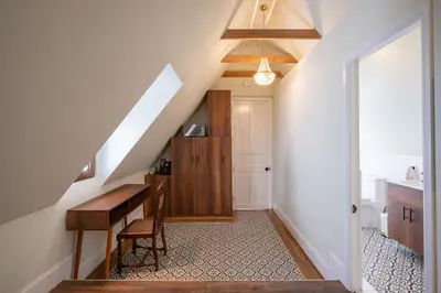 a hallway with a staircase with a desk and a kitchen at Casa Cáceres in Lima
