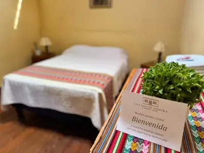 a room with two beds and a sign on a table at La Casa de Isidora in Pan de Azúcar