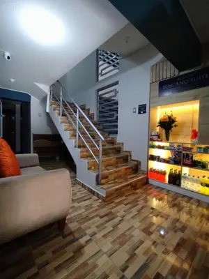 a living room with a staircase and a couch at HOSTAL TOSCANO SUITES in El Tambo