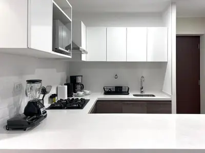 a kitchen with white cabinets and a blender on a counter at Peruvian Apartments Miraflores in Lima