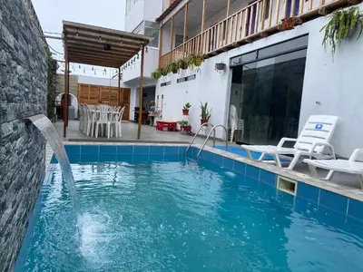 a swimming pool with a fountain in a house at Villa Alfonso - Casa playa con piscina temperada in Lima