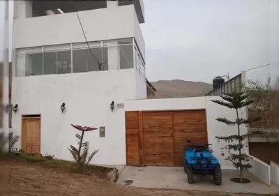 a blue motorcycle parked in front of a house at Villa Alfonso - Casa playa con piscina temperada in Lima