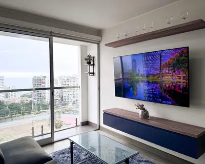 a living room with a large tv on the wall at Peruvian Apartments Barranco 1606 in Lima