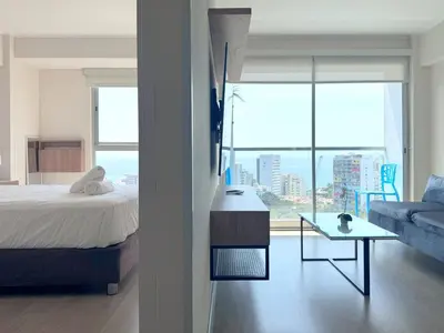 a bedroom with a bed and a living room with a couch at Peruvian Apartments Barranco 1609 in Lima