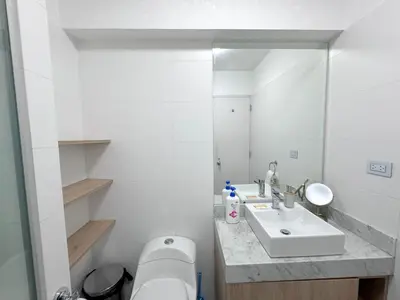 a white bathroom with a sink and a mirror at Peruvian Apartments Barranco 1609 in Lima