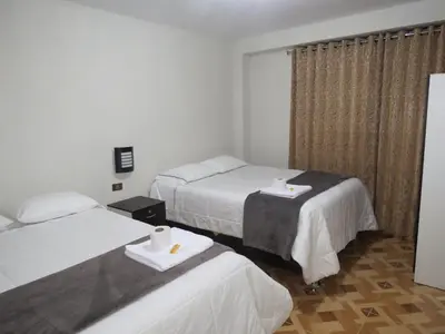 a hotel room with two beds and a window at Hospedaje EL RINCONCITO II - Cerca al Aeropuerto Jauja in Jauja