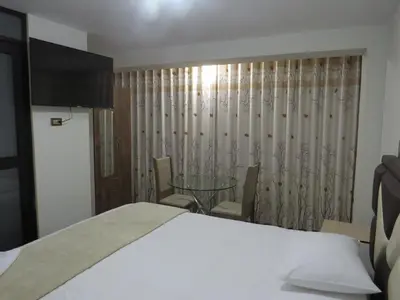 a bedroom with a bed and a glass table at Hospedaje EL RINCONCITO II - Cerca al Aeropuerto Jauja in Jauja