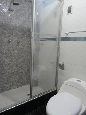 a bathroom with a toilet and a glass shower at Hospedaje EL RINCONCITO II - Cerca al Aeropuerto Jauja in Jauja
