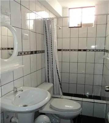 a white bathroom with a sink and a toilet at Sol de Paracas Apart Hotel Pisco in Pisco