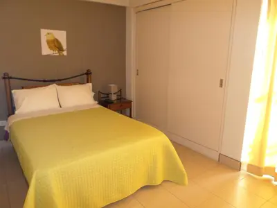 a bedroom with a bed with a yellow bedspread at Sol de Paracas Apart Hotel Pisco in Pisco